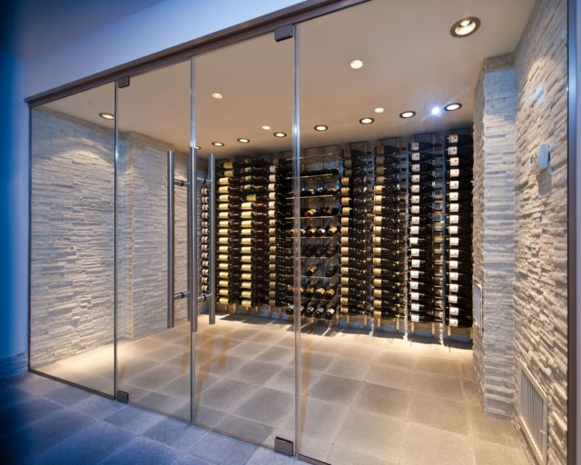 a wine cellar with glass doors and chrome hardware