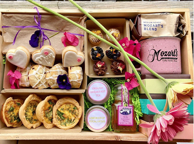 a top down view of a box of pastries, coffee, a mug, and some tea and gifts for mothers day